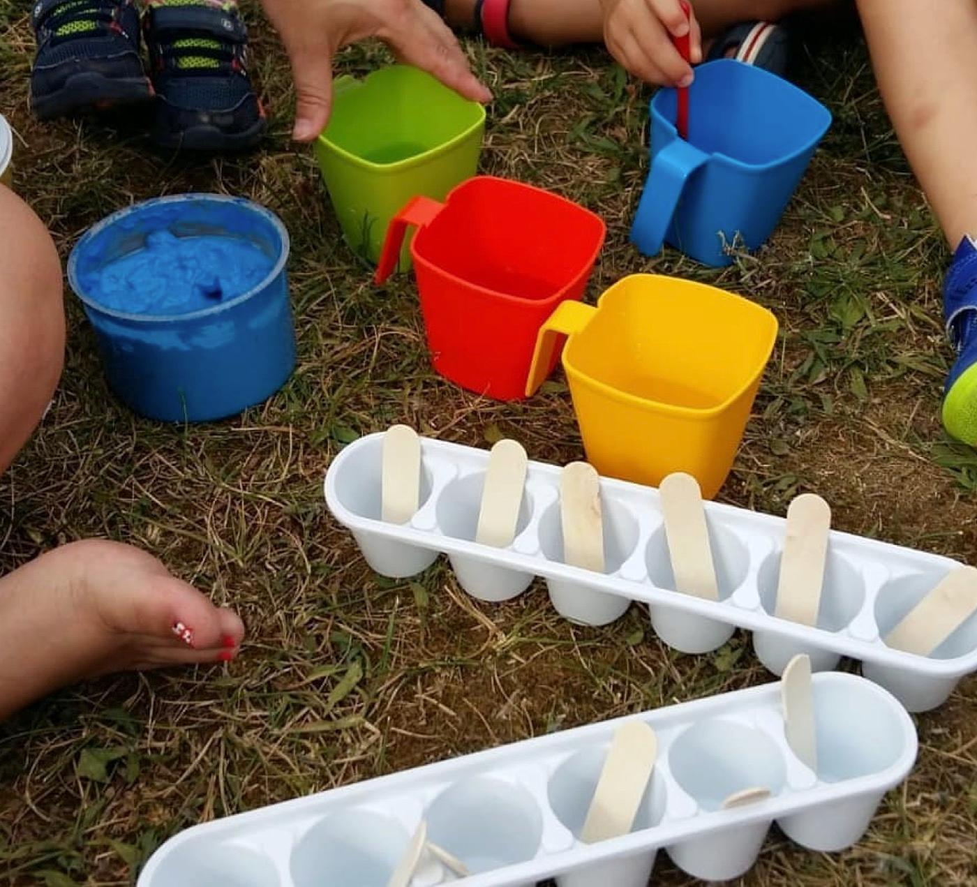 Cubos de hielo con palitos y cubos de colores para el juego con agua, en el patio